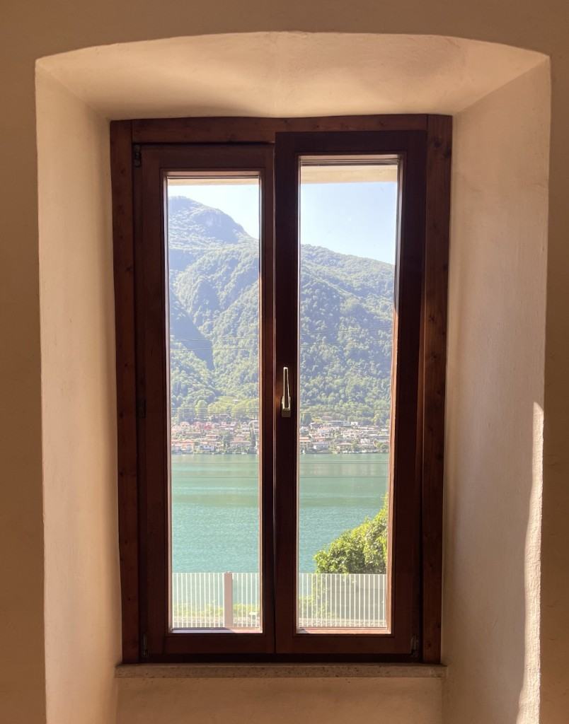 View of Lake Lugano through a window in the building